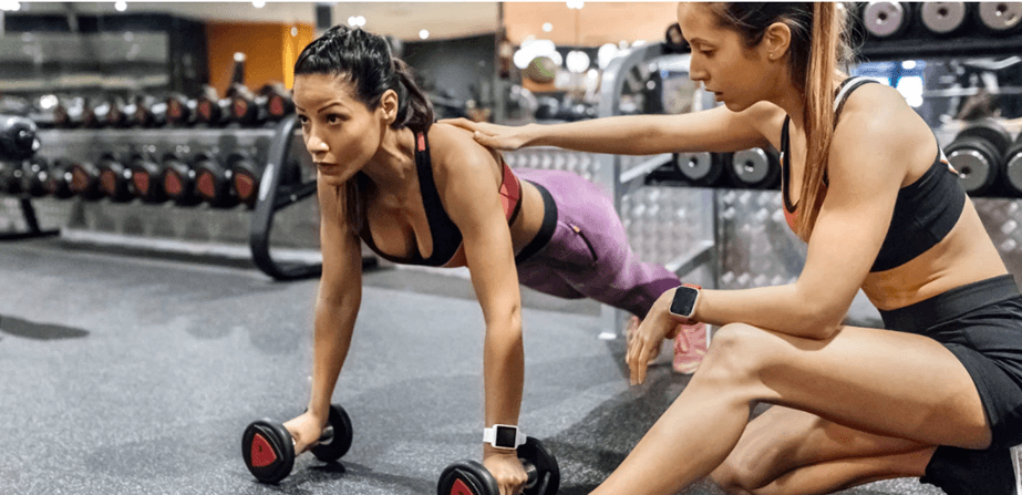 Fitness coach working with a client in gym